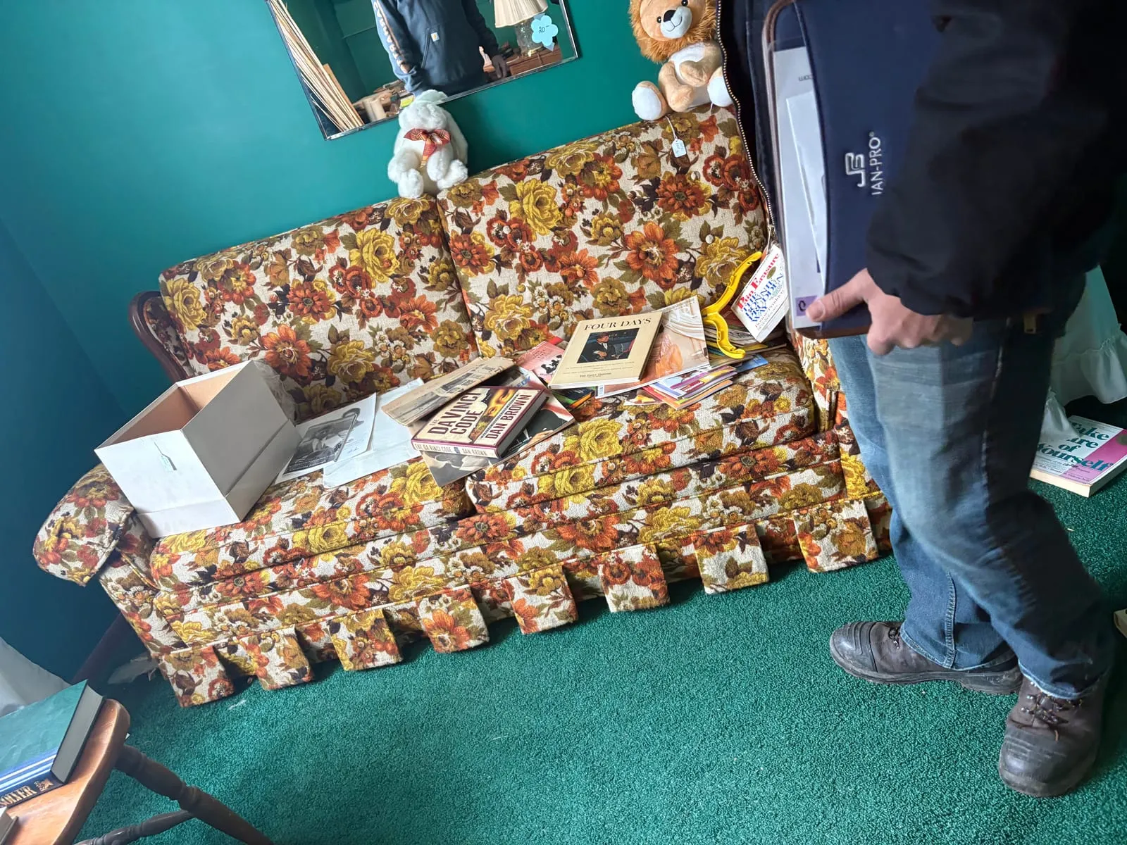Old floral couch in a living room before removal